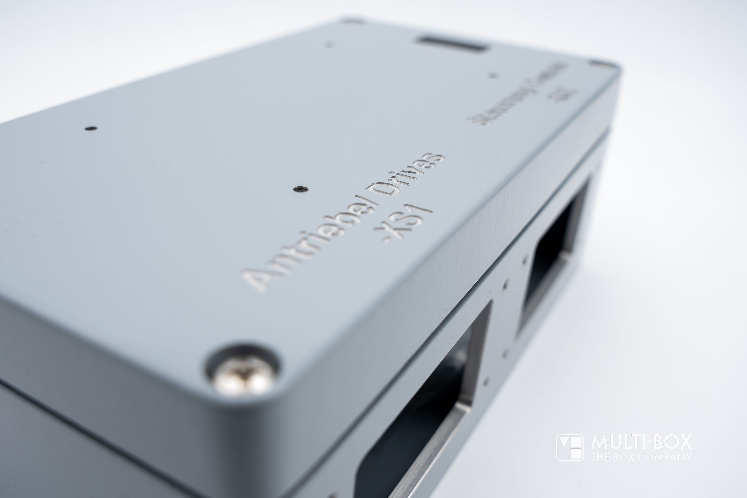 Close-up of a gray aluminum enclosure with an engraving "Antitribal Drives XSI."