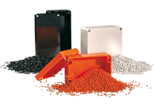 Kunststoffgranulat als Rohmaterial und fertige Kunststoffgehäuse in verschiedenen Farben für industrielle Anwendungen.