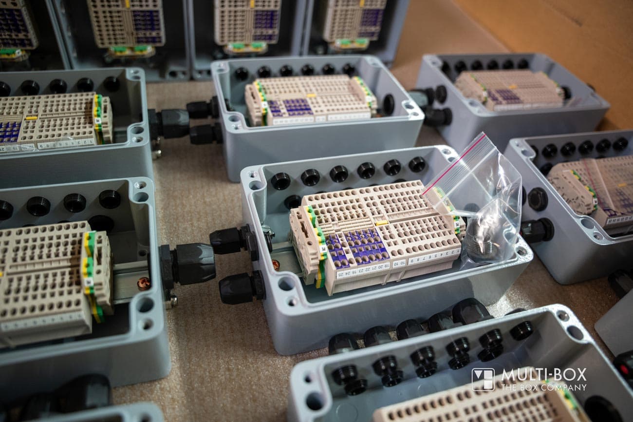 Multiple explosion-proof industrial enclosures with terminal blocks and cable glands prepared for electrical connections.